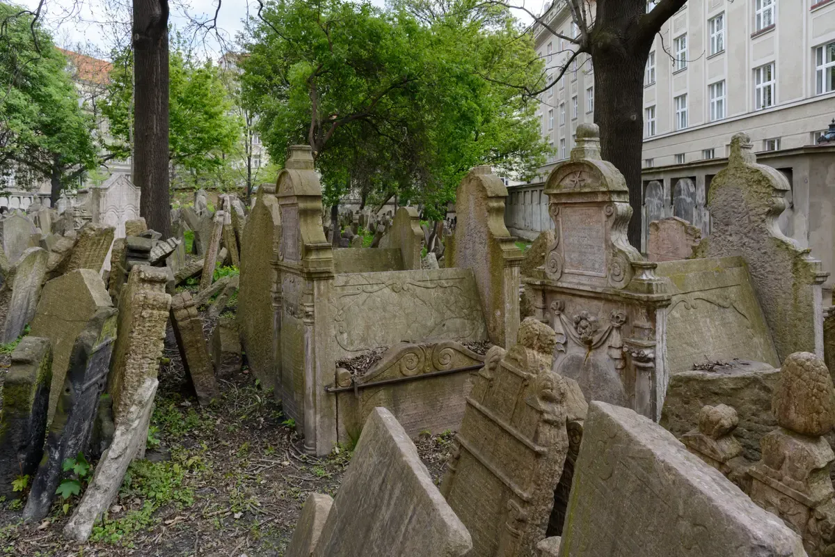 Leaning gravestones in the Old Jewish Cemetery under spring trees on a Prague Jewish Quarter tour